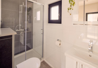 Baño moderno en Water lodge 2 + hot tub, Hofparken Wiltershaar, Países Bajos, con ducha y ventana.
