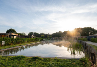 View of a pond at Water lodge 6 Deluxe with sauna and hot tub at Hofparken Wiltershaar, Netherlands.