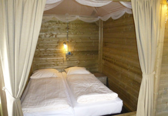 Deux lits jumeaux dans une chambre en bois du lodge Camphome au Holiday park Witterzomer aux Pays-Bas.