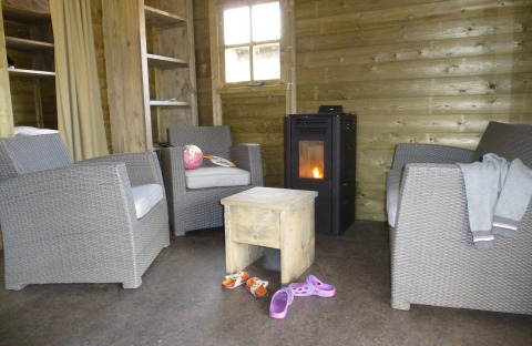 Gemütlicher Sitzbereich in einer Camphome-Lodge im Ferienpark Witterzomer mit Kaminofen.