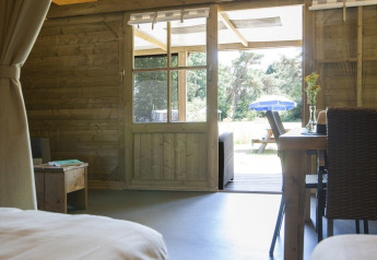 Vue depuis le lodge Camphome au Holiday park Witterzomer aux Pays-Bas, avec intérieur en bois et terrasse.