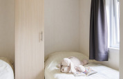 Gezellige slaapkamer in Chalet met Veranda op Vakantiepark Witterzomer, Nederland, met knuffeldier op bed.