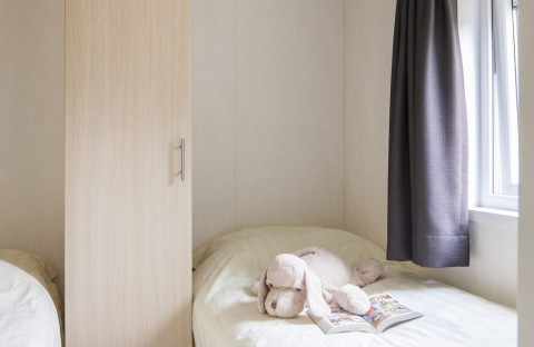 Gezellige slaapkamer in Chalet met Veranda op Vakantiepark Witterzomer, Nederland, met knuffeldier op bed.