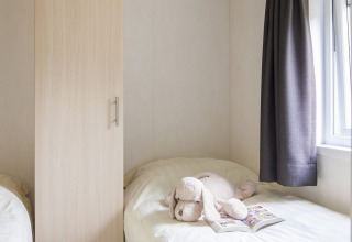 Chambre confortable du Chalet avec Véranda au Holiday park Witterzomer, Pays-Bas, avec peluche sur le lit.