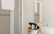 Bagno con doccia, asciugamano bianco e beauty case nella Lodge presso Holiday park Witterzomer, Paesi Bassi.