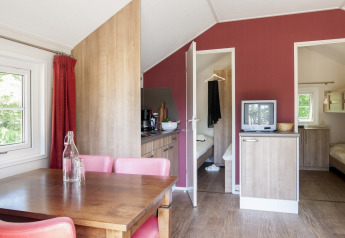 Innenansicht einer Lodge im Holiday Park Witterzomer in den Niederlanden, mit Essecke und Schlafzimmern.