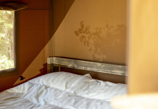 Vista interna della tenda Safari presso Holiday park Witterzomer, Paesi Bassi, con letto soleggiato.