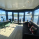 Salón moderno en Houseboat Marina Mookerplas con amplios ventanales y vistas espectaculares al lago tranquilo.