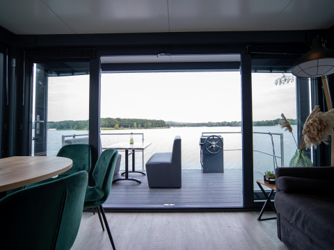 Casa flotante moderna en Marina Mookerplas, sala abierta con vistas al lago en los Países Bajos.