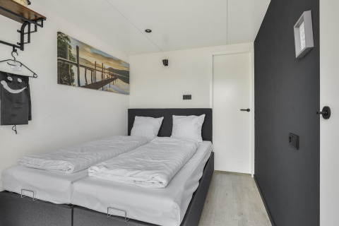 Moderne soveværelse på Houseboat Marina Mookerplas med to enkeltsenge og minimalistisk indretning.