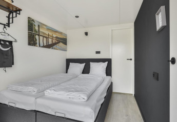 Dormitorio moderno en Houseboat Marina Mookerplas con dos camas individuales y decoración minimalista.