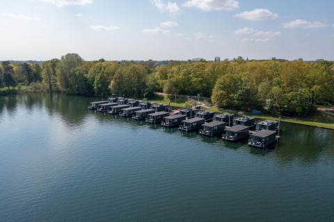 Vista de casas flotantes en Houseboat Marina Mookerplas, Marina Mookerplas, junto al bosque en los Países Bajos.