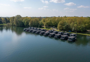 Vista de casas flotantes en Houseboat Marina Mookerplas, Marina Mookerplas, junto al bosque en los Países Bajos.