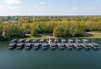 Vista aerea delle houseboat alla Marina Mookerplas nei Paesi Bassi, ormeggiate vicino alla riva alberata.