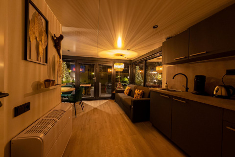 Gezellig interieur van een moderne woonboot aan Marina Mookerplas, Nederland, met keuken en sfeerverlichting.
