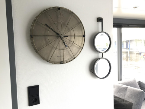 Wand mit modernem Zifferblatt und zwei Spiegeln an Bord des Hausboots Houseboat Heeg in Marina Heeg, Niederlande.