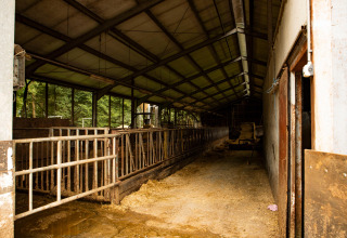 Binnenzicht van een lege stal bij Feather Down Landgoed Volenbeek vakantiepark in Gelderland, Nederland.