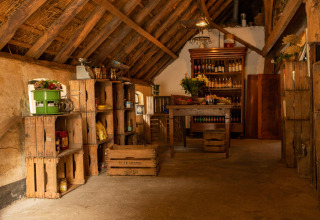 Rustiek interieur van een hoevewinkel met houten kratten bij Feather Down Landgoed Volenbeek in Gelderland.