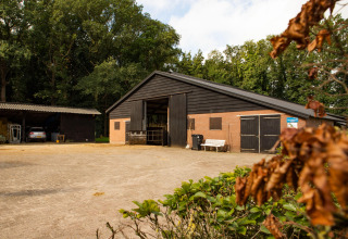 Schuur en omgeving op Feather Down Landgoed Volenbeek vakantiepark in Gelderland, Nederland, zichtbaar.