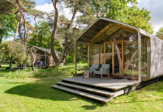 Wikkelhouse XL-lodge bij Beerze Bulten in Nederland, te midden van bomen en een groene omgeving.