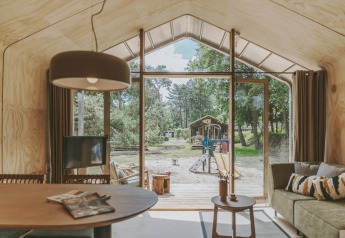 Vista interna della Wikkelhouse XL lodge a Beerze Bulten nei Paesi Bassi, affacciata sul parco giochi.