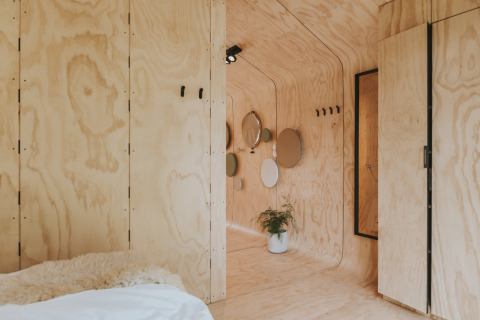 Intérieur du Wikkelhouse XL à Beerze Bulten, Pays-Bas, en contreplaqué clair et décoration minimaliste.