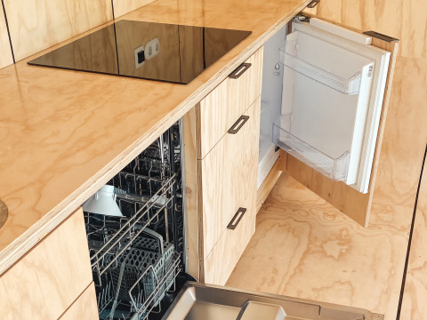 Cocina moderna con lavavajillas y frigorífico abiertos en Wikkelhouse XL de Beerze Bulten, Países Bajos.
