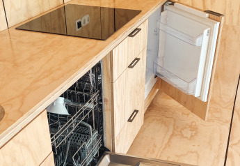 Moderne keuken met open vaatwasser en koelkast in Wikkelhouse XL bij Beerze Bulten, Nederland.