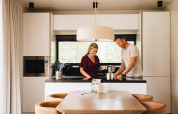 Una pareja cocina junta en la moderna cocina de Hill Lodge en Beerze Bulten, Países Bajos, con área de comedor.