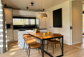 Modern kitchen and dining area at Hill Lodge, Beerze Bulten in the Netherlands, with four chairs and juice.