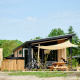 Sand Lodge Jacuzzi tiny house med cykler og picnicbord i Holiday Park De IJsvogel, Holland, omgivet af natur.
