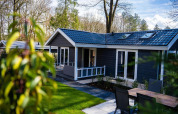 Heuvelrug Cottage med moderne tag og terrasse på De Thijmse Berg, omgivet af træer i Holland.