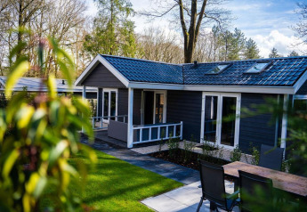 Heuvelrug Cottage med moderne tag og terrasse på De Thijmse Berg, omgivet af træer i Holland.