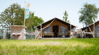 Safari tent Villatent Compact with private bathroom, hammocks and green area on a sunny day