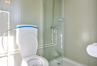 Baño moderno con inodoro y ducha en la tienda safari Villatent Compact con baño privado y sanitario.