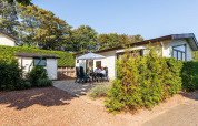 Casa de vacaciones en EuroParcs Noordwijkse Duinen, Países Bajos, con personas disfrutando de la terraza.