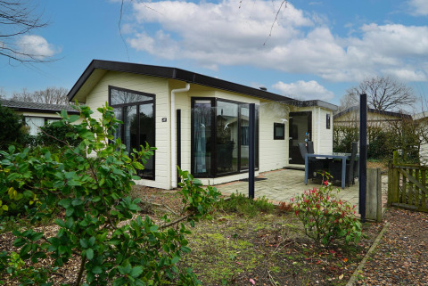 Ferienhaus im EuroParcs Noordwijkse Duinen in den Niederlanden mit Terrasse und Garten bei Tageslicht.
