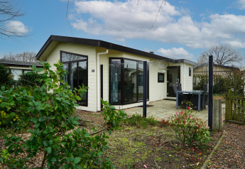 Vakantiehuis bij EuroParcs Noordwijkse Duinen in Nederland met terras, tuin en zitgedeelte buiten.