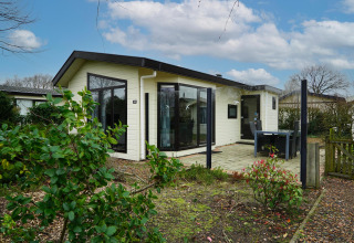 Casa de vacaciones en EuroParcs Noordwijkse Duinen, Países Bajos, con terraza, jardín y área de comedor exterior.