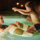 Una madre y su hija juegan alegres en la piscina iluminada de Unbrick One Family | Sauna and Pool en De Weelderik, Países Bajos.