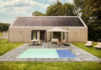 Lodge moderno con paneles solares, terraza, piscina y asientos exteriores en De Weelderik, Países Bajos.