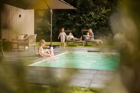 Famiglia che si rilassa in piscina a Unbrick One Family | Sauna e Piscina presso De Weelderik, Paesi Bassi.