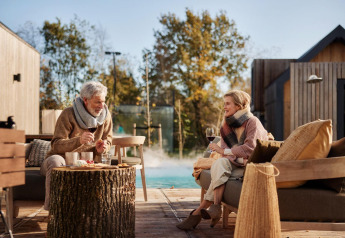 Ouder stel geniet van wijn bij Unbrick One | Sauna en Pool op De Weelderik, Nederland, buitenterras.