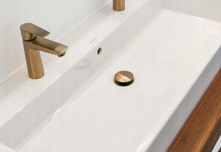 Grifería doble dorada moderna con lavabo blanco en Unbrick One, De Weelderik, Países Bajos.