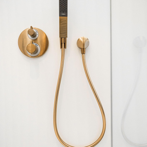 Robinetterie de douche moderne en laiton sur mur blanc à Unbrick One | Sauna et Piscine à De Weelderik, Pays-Bas.