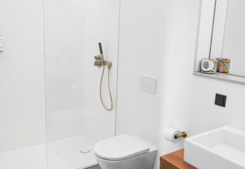 Bagno moderno con wc sospeso, doccia in vetro e mobile in legno presso Unbrick One lodge nei Paesi Bassi.