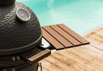 Schwarzer Keramikgrill mit Thermometer und Holzablage am Pool, aufgenommen bei Unbrick One, De Weelderik.