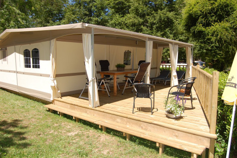 Safari glamping tent Cahors at La Draille in France, with spacious wooden deck, chairs, and relaxing vibe.