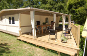 Tienda de glamping tipo safari Cahors en La Draille, Francia, con terraza de madera y sillas exteriores.