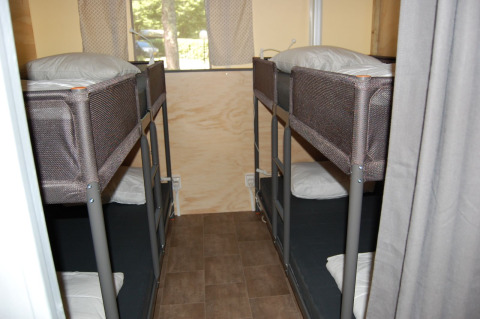 Vier slaapplaatsen in stapelbedden in een safaritenthut bij Glampingtent Cahors, La Draille, Frankrijk.